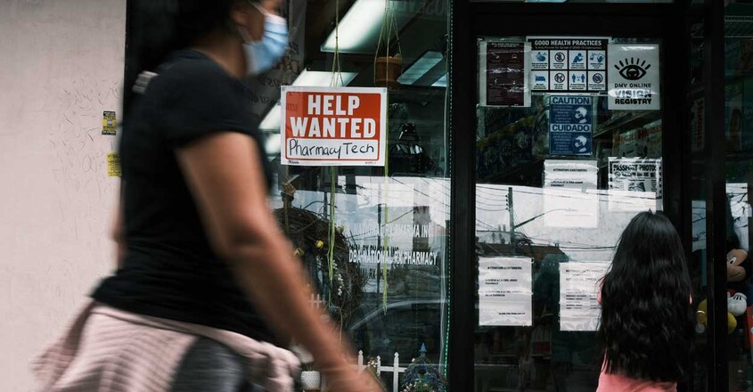 People walk by a Help Wanted sign in the Queens borough of New York City People walk by a Help Wanted sign in the Queens borough of New York City