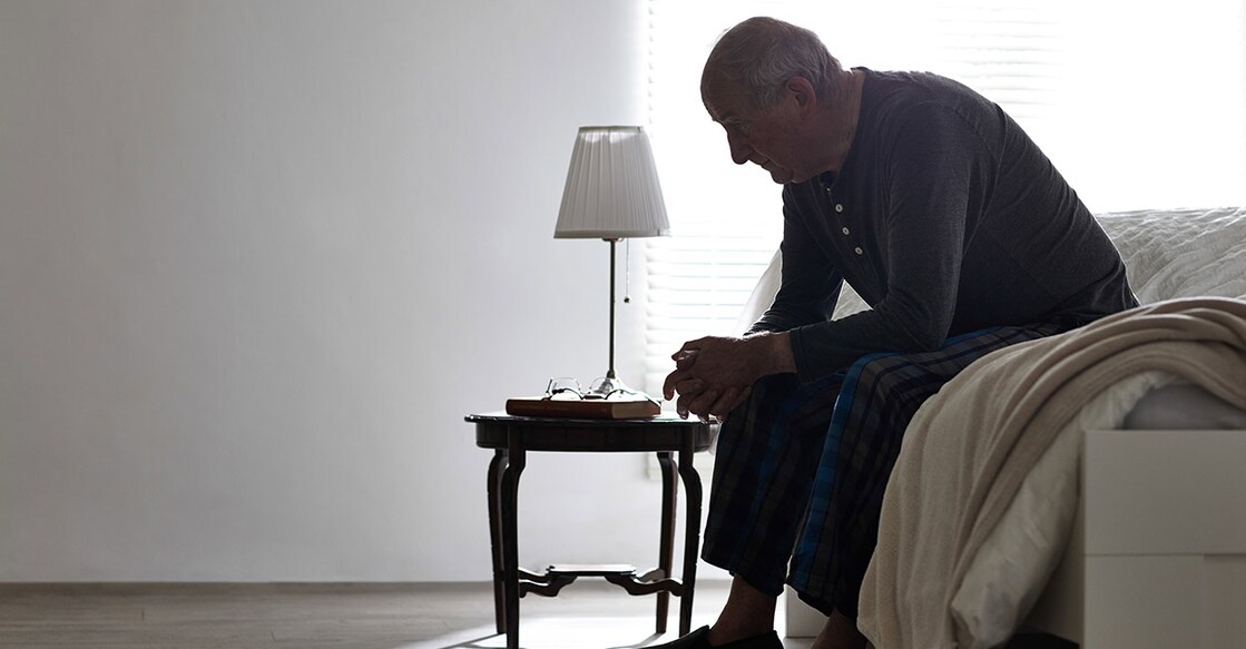 elderly-man-sitting-on-bed-looking-serious-indoors-dean-mitchell-istock-photo-com