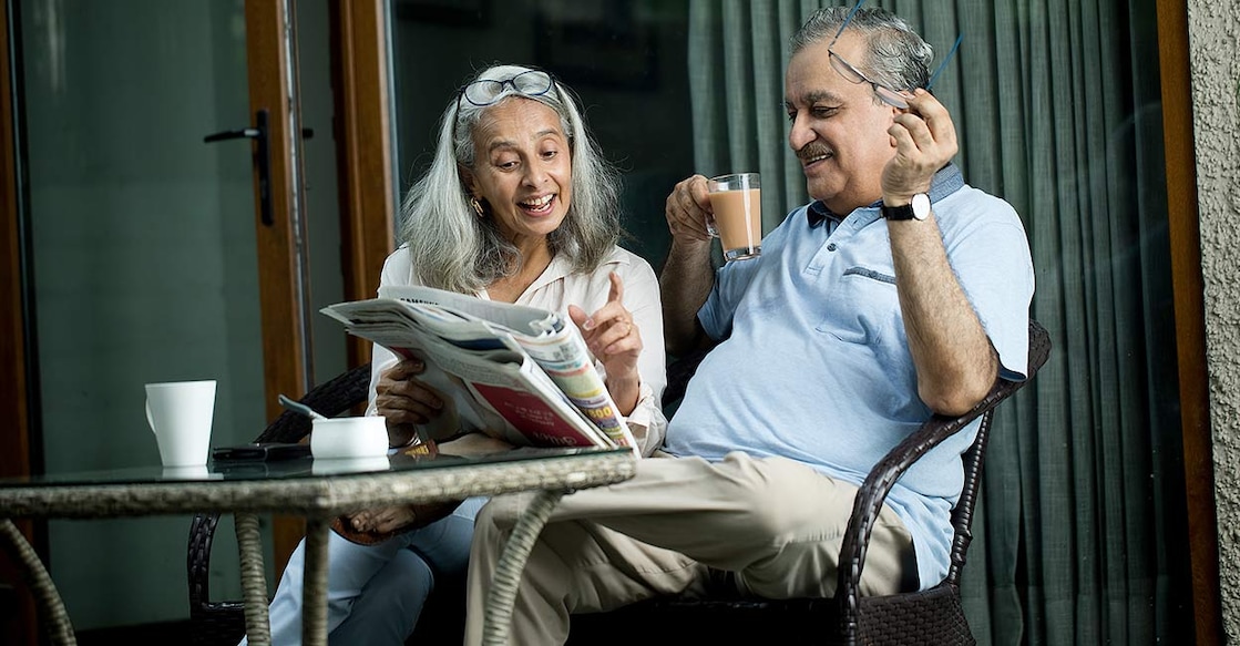 senior-citizen-reading-newspaper-tea-smiling-happy-mode-triloks-istock-photo-com