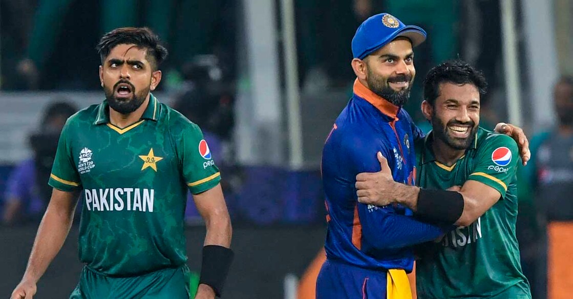 India's captain Virat Kohli (C) congratulates his Pakistan's counterpart Babar Azam (L) and Mohammad Rizwan following their victory during the ICC men’s Twenty20 World Cup cricket match between India and Pakistan at the Dubai International Cricket Stadium in Dubai on October 24, 2021. (Photo by Aamir QURESHI / AFP)