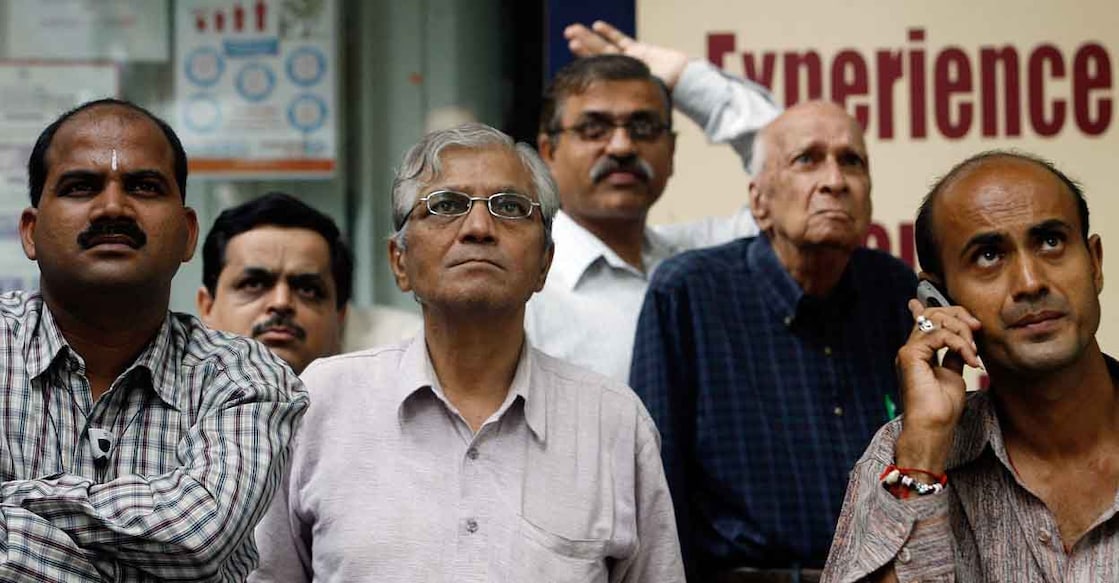 INDIA-ECONOMY-STOCKS Indian investors watch a digital screen displaying the Sensex during intra-day trade outside The Bombay Stock Exchange (BSE) in Mumbai, 17 August 2007. Indian share prices fell 1.51 percent in volatile and nervous trade Friday but pared back steep intraday losses, amid jittery Asian markets as fears persist of a widening impact of the US housing loan problem, dealers said. The benchmark 30-share Sensex index closed down 1.51 percent at 14,141.52, off the three-month low of 13,779.88, hit earlier in the day. AFP PHOTO/ Indranil MUKHERJEE (Photo by INDRANIL MUKHERJEE / AFP)