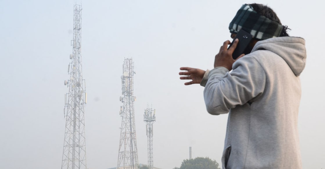 A man talks on his mobile phone near a telecom tower, on the outskirts of Amritsar on December 30, 2020. (Photo by NARINDER NANU / AFP)
