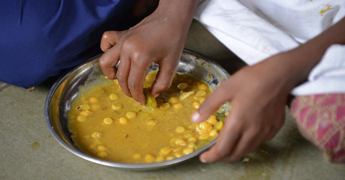 An Indian pupil at Jahangirpura Shala Number 2, which is run by the Ahmedabad Municipal Corporation, eats a free mid-day meal in Ahmedabad on July 17, 2013. Twenty-two children have died in India's Bihar state after eating a free lunch feared to contain poisonous chemicals at an Indian primary school, officials said July 17, as the tragedy sparked angry street protests.  AFP PHOTO / Sam PANTHAKY (Photo by SAM PANTHAKY / AFP)