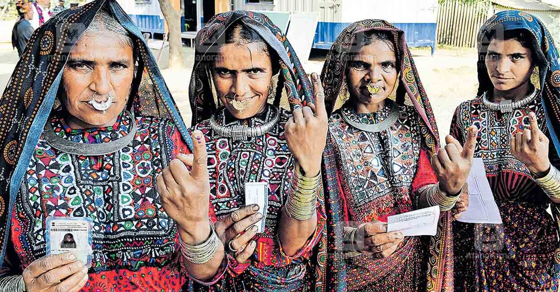 gujarat-assembly-election-2022 ഒരു കണ്ടെയ്നർ വോട്ട്! ഗുജറാത്ത് തിരഞ്ഞെടുപ്പിൽ ഭാരുഛിലെ വിദൂരഗ്രാമമായ ആലിയബേട്ടിൽ കണ്ടെയ്നറിൽ ഒരുക്കിയ പോളിങ് ബൂത്തിൽ വോട്ടു ചെയ്തു മടങ്ങുന്ന സ്ത്രീകൾ. മുൻകാലങ്ങളിൽ 70 കിലോമീറ്റർ സഞ്ചരിച്ചാണു ഗ്രാമവാസികൾ വോട്ട് ചെയ്തിരുന്നത്. ചിത്രം: സജീഷ് ശങ്കർ ∙ മനോരമ