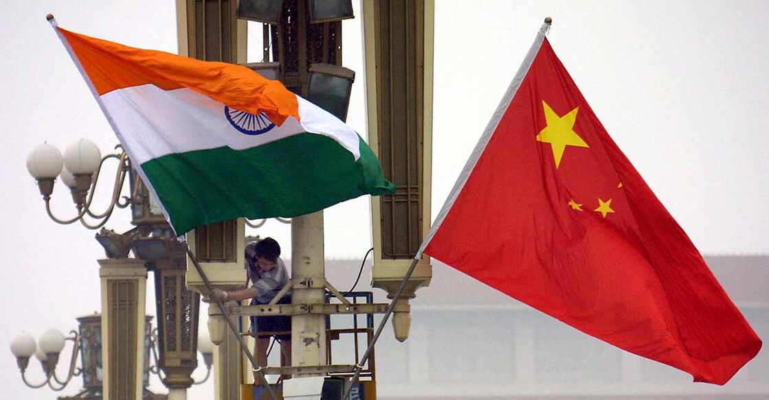 Workers put up the Indian flag (L) alongside the Chinese flag on Tiananmen Square in Beijing, 22 June 2003, ahead of Indian Prime Minister Atal Behari Vajpayee's arrival. Vajpayee's visit is the first to China by an Indian premier in a decade, as the two Asian giants which account for a third of the world's population, have had unsteady relations since a bloody 1962 border war, while fifteen rounds of talks since the 1980s have failed to resolve their boundary disputes.     AFP PHOTO (Photo by AFP)