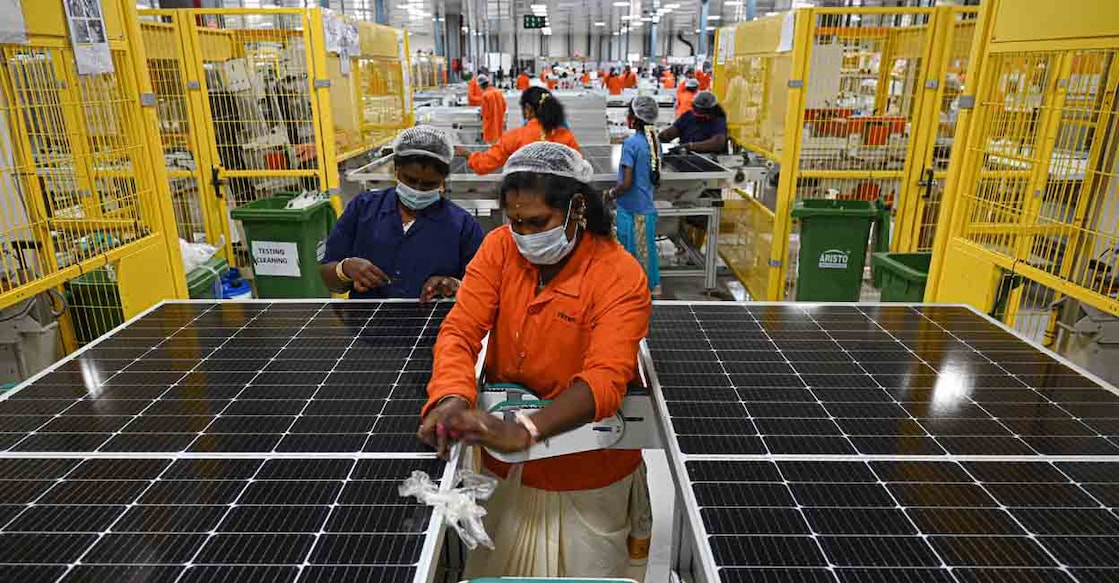 In this photo taken on October 13, 2021, employees work at the Vikram Solar manufacturing plant in Oragadam, in the southern Indian state of Tamil Nadu. - Currently, coal powers 70 percent of the nation's electricity generation, but Indian Prime Minister Narendra Modi pledged on November 1 that it would produce more energy than India's entire grid now through solar and other renewables by 2030. (Photo by Arun SANKAR / AFP) / TO GO WITH Climate-UN-COP26-energy-solar,FEATURE by Glenda KWEK