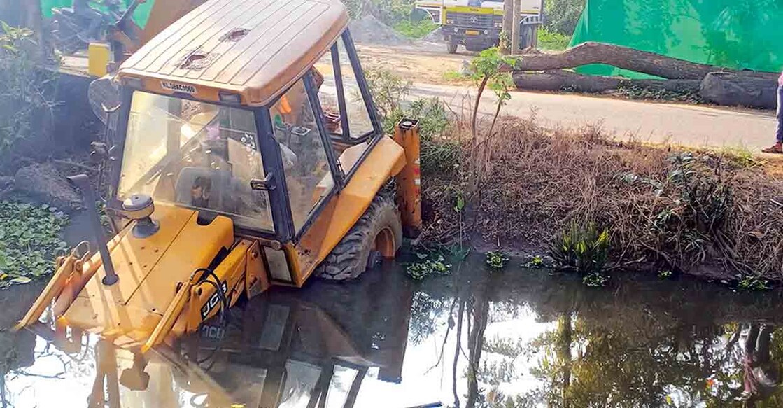 കുമരകം പള്ളിച്ചിറയ്ക്കു സമീപം കെട്ടിട നിർമാണ സാമഗ്രികൾ സംഭരിക്കുന്ന സ്ഥലത്തുനിന്നു തനിയെ നീങ്ങിയ മണ്ണുമാന്തി യന്ത്രം കുമരകം റോഡിലൂടെ കടന്നു തോട്ടിൽ വീണപ്പോൾ. ടോറസ് ലോറി കിടക്കുന്ന സ്ഥലത്തുനിന്നാണു മണ്ണുമാന്തി യന്ത്രം തനിയെ നീങ്ങിയത്. 