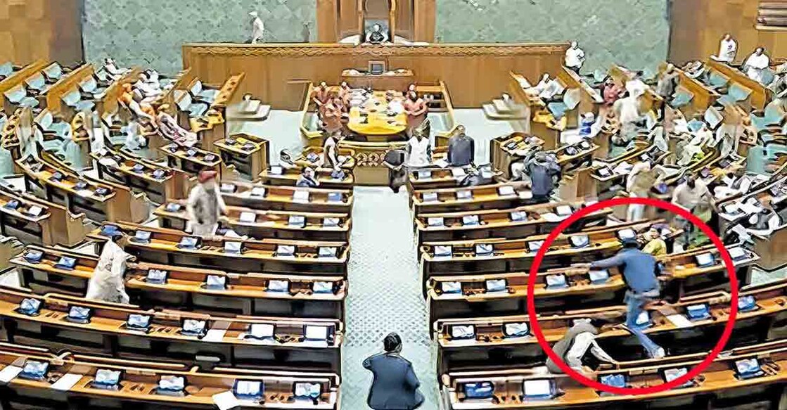 parliament-security-breach ലോക്സഭാ ഹാളിലേക്കു കടന്നുകയറിയ യുവാക്കളിൽ ഒരാൾ എംപിമാർ പിടിക്കാൻ ശ്രമിച്ചതോടെ മേശകൾക്കു മുകളിലൂടെ ചാടുന്നു. (ഫയൽ ചിത്രം)
