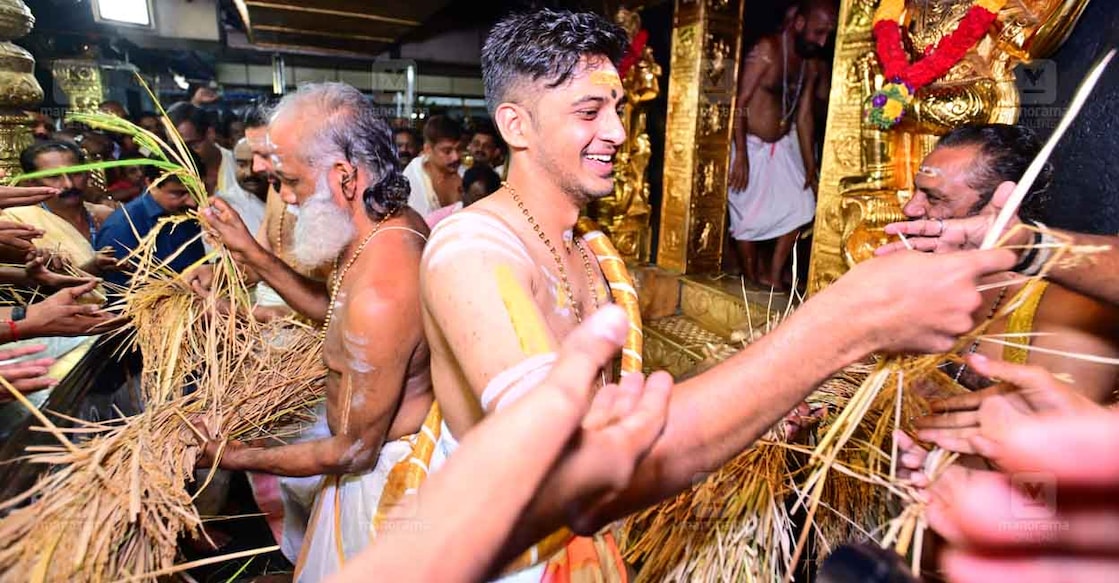 Sabarimala ശബരിമലയിൽ നിറപുത്തരിക്കു പൂജിച്ച് ചൈതന്യം നിറച്ച നെൽക്കതിരുകൾ കണ്ഠര് ബ്രഹ്മദത്തൻ, മേൽശാന്തി കെ.ജയരാമൻ നമ്പൂതിരി, തന്ത്രി കണ്ഠര് രാജീവര് എന്നിവർ ഭക്തർക്കു പ്രസാദമായി നൽകുന്നു. (ഫയൽ ചിത്രം: മനോരമ)