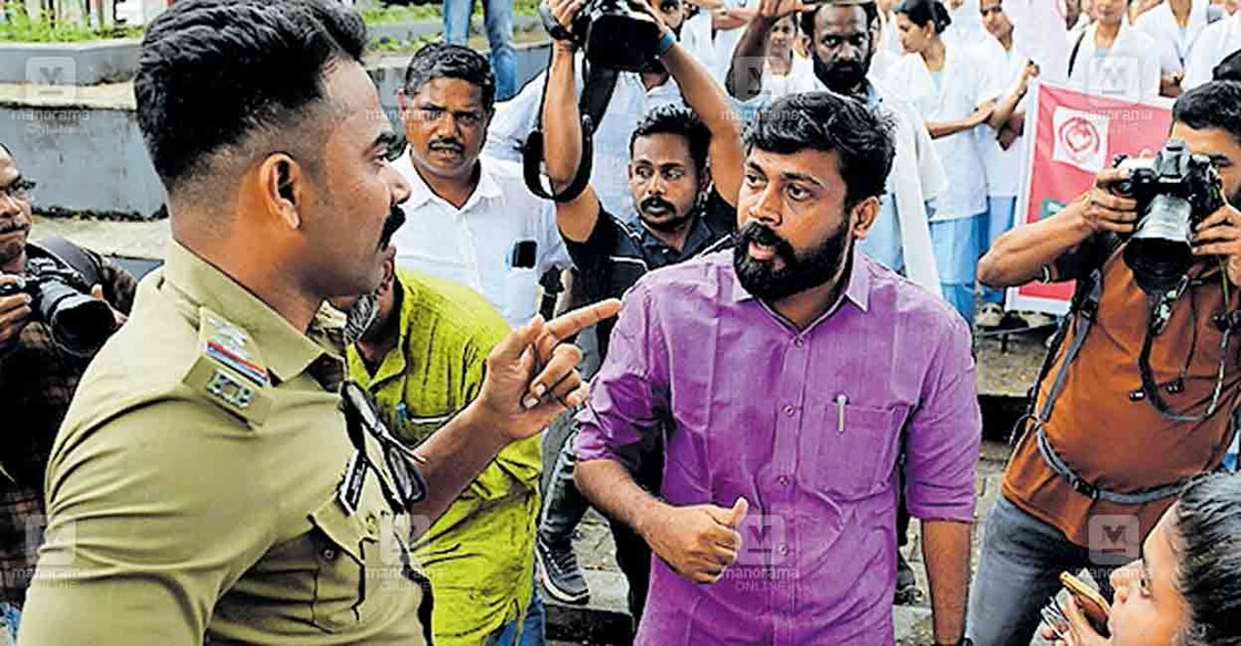 എസ്ഐ പി.പി.ഷമീൽ എം.വിജിൻ എംഎൽഎയുമായി തർക്കിക്കുന്നു. ചിത്രം: മനോരമ  