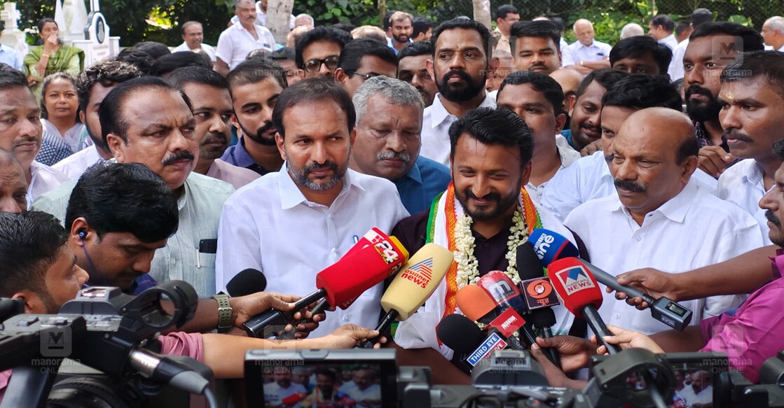 പുതുപ്പള്ളി പള്ളിയിലെ ഉമ്മൻ ചാണ്ടിയുടെ  കല്ലറയിൽ എത്തി പ്രാർഥിച്ചതിന് പിന്നാലെ സംസാരിക്കുന്ന രാഹുൽ മാങ്കൂട്ടത്തിൽ. (ചിത്രം: റിജോ ജോസഫ്∙മനോരമ)