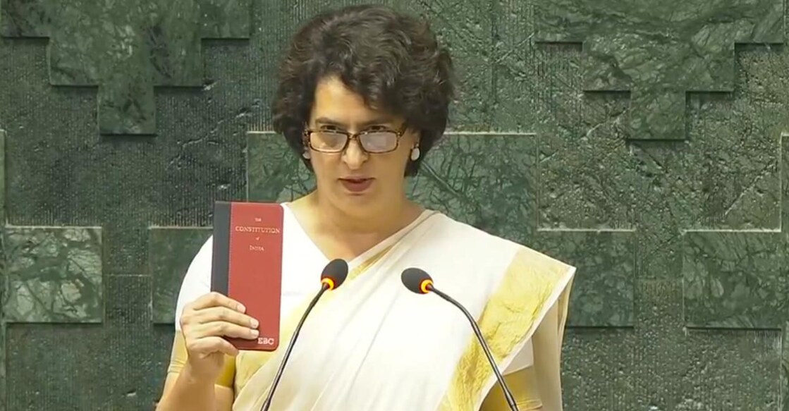 ഭരണഘടനയുടെ ചെറു മാതൃക കയ്യിലേന്തി വയനാട് എംപിയായി സത്യപ്രതിജ്ഞ ചെയ്യുന്ന പ്രിയങ്ക ഗാന്ധി. (Photo: X/SansadTV)