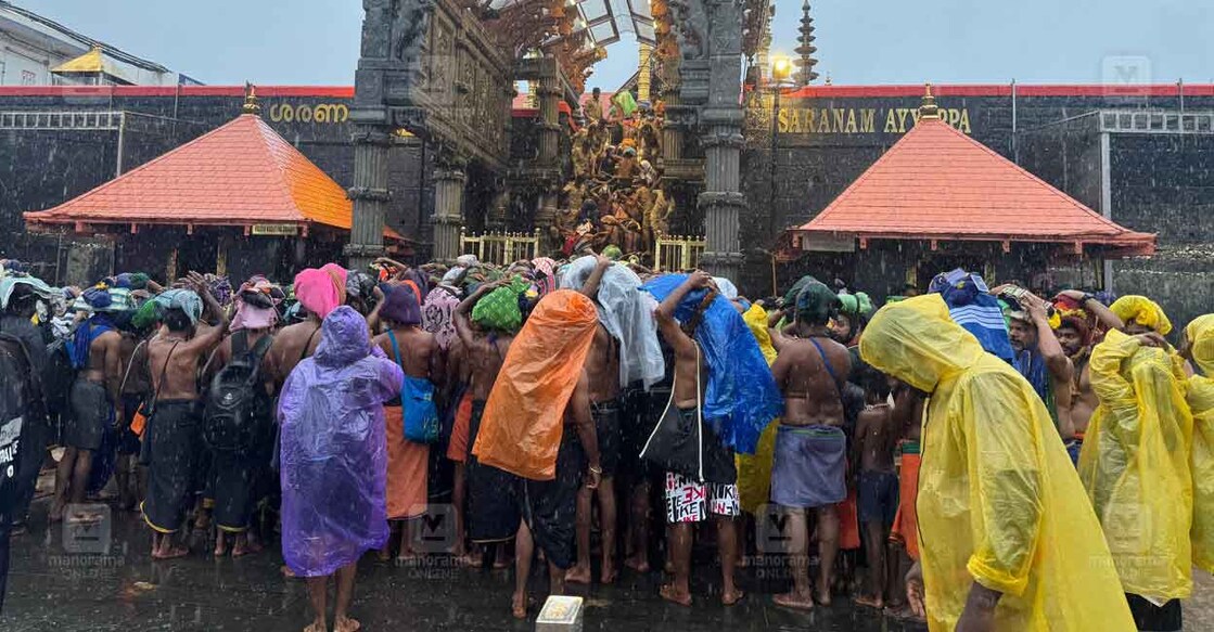 ശബരിമലയിൽ കനത്ത മഴയത്ത് പതിനെട്ടാംപടി കയറുന്നവർ. ചിത്രം:ഹരിലാൽ/മനോരമ
