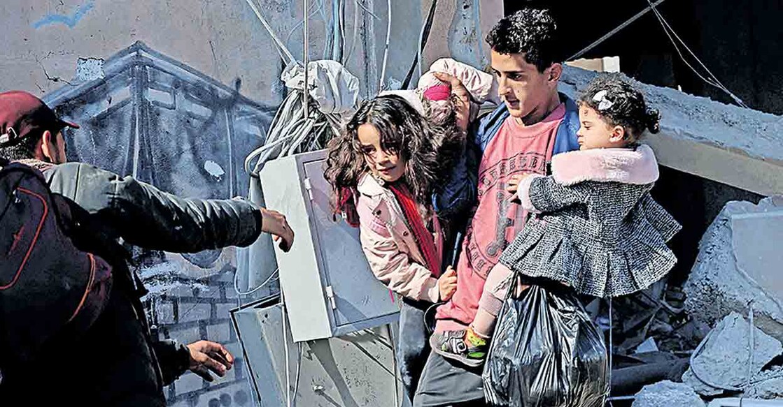 israel-attack-gaza-children ഇസ്രയേൽ വ്യോമാക്രമണത്തിൽ തകർന്ന റഫയിലെ വീട്ടിൽനിന്ന് കുട്ടികളുമായി രക്ഷപ്പെടുന്ന യുവാവ്. ചിത്രം: എഎഫ്പി