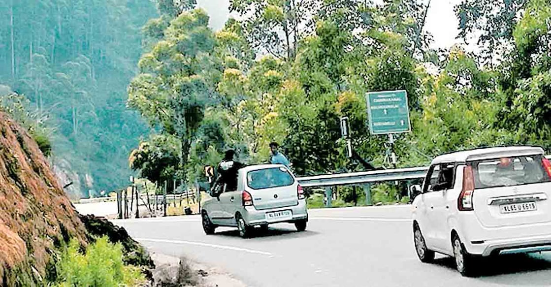 dangerous-car-travel ദേവികുളം ഗ്യാപ് റോഡ് വഴി പോകുന്ന വാഹനത്തിൽ അപകടകരമായ സാഹചര്യത്തിൽ യാത്ര ചെയ്യുന്ന യുവാവ്.