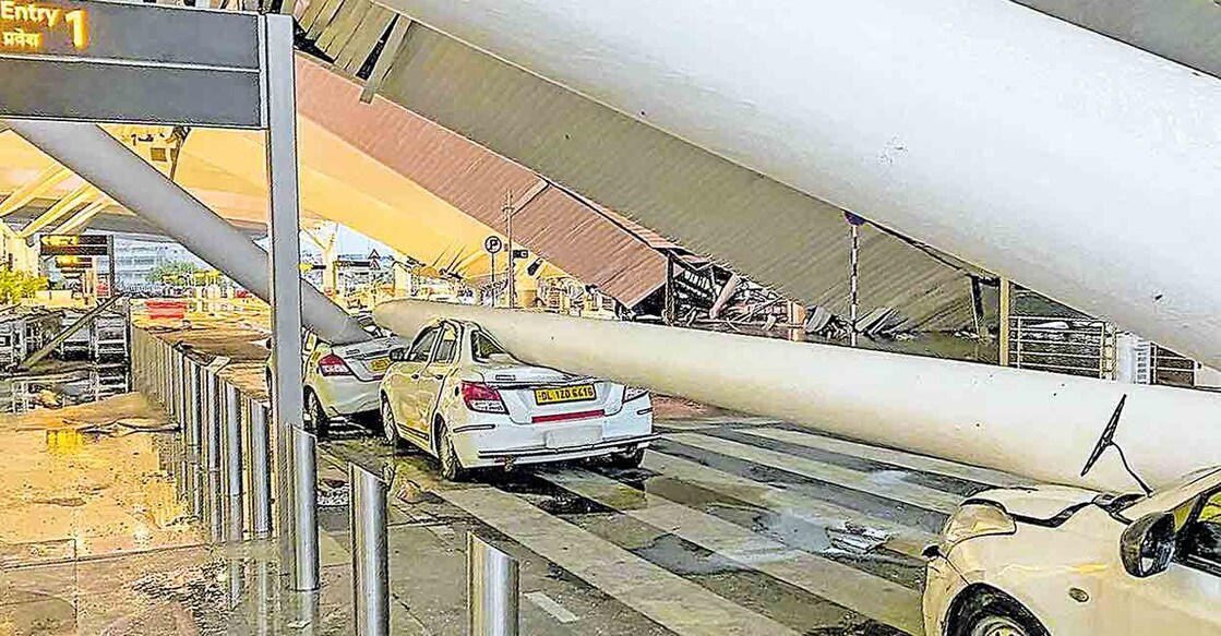 delhi-airport-tragedy ഡൽഹി രാജ്യാന്തര വിമാനത്താവളത്തിലെ ടെർമിനൽ ഒന്നിനു മുന്നിലെ മേൽക്കൂരയും തൂണും വിമാന യാത്രക്കാർക്കുവേണ്ടി നിർത്തിയിട്ടിരുന്ന കാറുകളുടെ മീതേ തകർന്നു വീണപ്പോൾ. ചിത്രം: പിടിഐ
