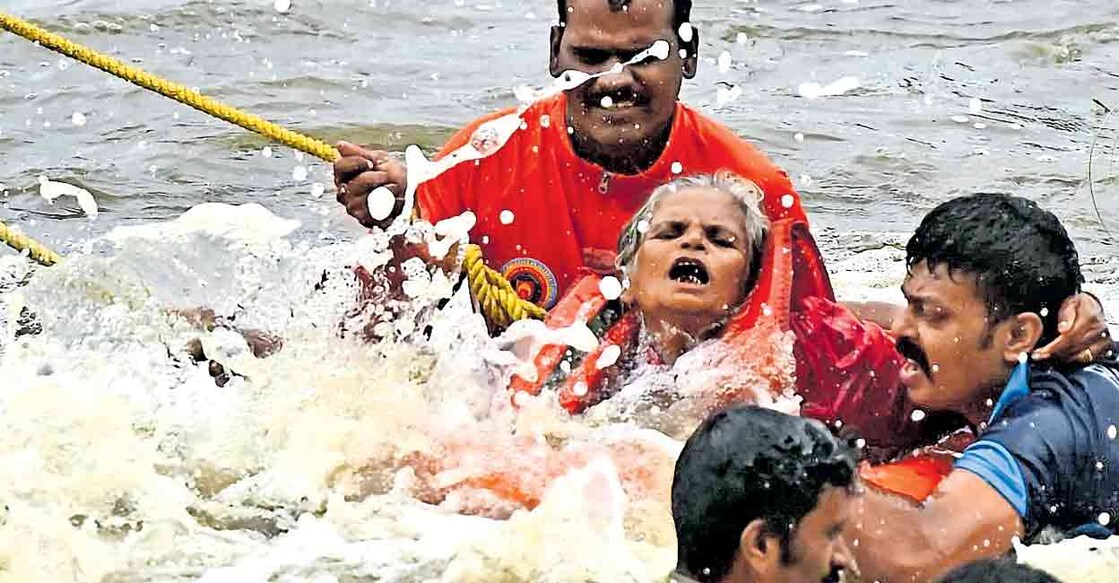 മിന്നൽ രക്ഷ: പാലക്കാട് ചിറ്റൂർ ആലാംകടവ് കോസ്‌വേയ്ക്കു സമീപം പുഴയിൽ കുളിക്കാനിറങ്ങിയപ്പോൾ പൊടുന്നനെ ജലനിരപ്പുയർന്നു പാറയ്ക്കു മുകളിൽ കുടുങ്ങിയ ദേവിയെ അഗ്നിരക്ഷാ സേനാംഗങ്ങൾ രക്ഷപ്പെടുത്തി കരയ്‌ക്കെത്തിക്കുന്നു. ദേവിയുടെ ഭർത്താവും മകനും കൊച്ചുമകനുമടക്കം നാലു പേരാണു കുടുങ്ങിയത്. നാലുപേരെയും രക്ഷിച്ചു. ചിത്രം: വിബി ജോബ് ∙ മനോരമ