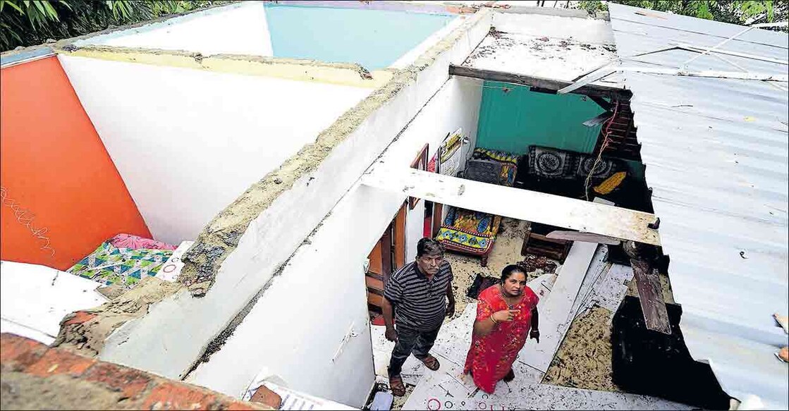 wind-havoc ശക്തമായ കാറ്റിൽ മേൽക്കൂര പറന്നുപോയ വീട്ടിൽ ആലപ്പുഴ പഴവീട് പള്ളാത്തുരുത്തി പുത്തൻചിറ ഹരിലാലും ഭാര്യ നിർമലയും. ചിത്രം: മനോരമ