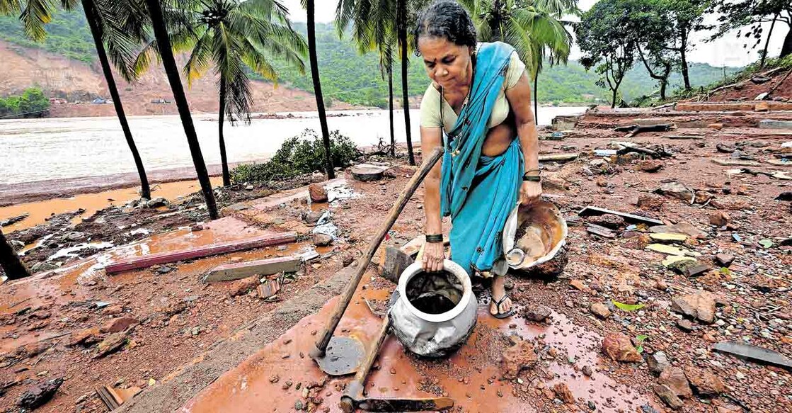 നോവാണു പുഴ... കർണാടകയിലെ ഷിരൂരിൽ കുന്നിടിഞ്ഞ് ഗംഗാവലി നദിയിലേക്കു വീണപ്പോളുണ്ടായ സൂനാമി പോലുള്ള ജലപ്രവാഹത്തിൽ ഒഴുകിപ്പോയ സന്നി ഹനുമന്ത ഗൗഡയുടെ തകർന്ന വീട്ടിലെത്തിയ സഹോദരി സന്നി ഭീരഗൗഡ. വെള്ളം ഇരച്ചെത്തിയപ്പോൾ വീട്ടിൽ പാചകം ചെയ്തു കൊണ്ടിരിക്കുകയായിരുന്ന സന്നി ഹനുമന്തയെ ഇതുവരെ കണ്ടെത്തിയിട്ടില്ല. ഇവിടെ ആറിലധികം വീടുകൾ വെള്ളം ഇരച്ചുകയറി തകർന്നു. ചിത്രം: അഭിജിത്ത് രവി / മനോരമ 