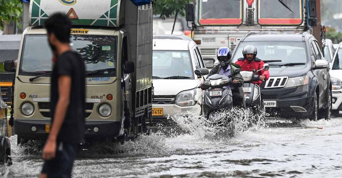 Mumbai flood മുംബൈയിൽ പുലർച്ചെ പെയ്ത കനത്ത മഴയിൽ വെള്ളത്തിലായ റോഡിലൂടെ വാഹനങ്ങൾ നീങ്ങുന്നു. (Photo: Punit Paranjpe / AFP)