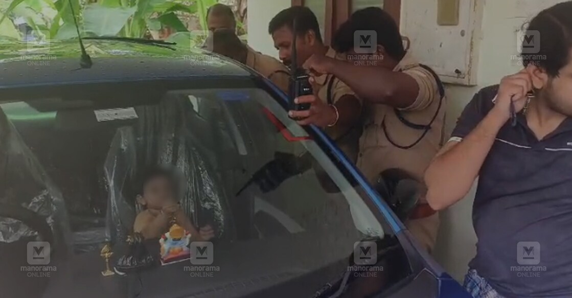 കാറിനുള്ളിൽ അകപ്പെട്ട കുട്ടിയെ പുറത്തെത്തിക്കാൻ ശ്രമിക്കുന്ന ഫയർഫോഴ്സ് അംഗങ്ങൾ