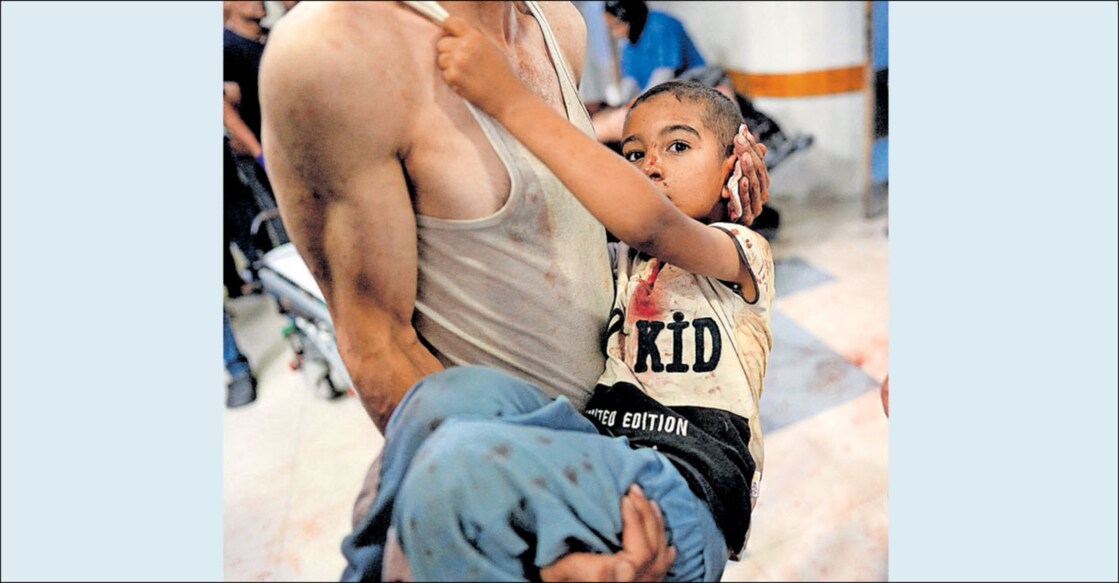 palestine-youth-took-child-to-hospital ഇസ്രയേൽ ആക്രമണത്തിൽ പരുക്കേറ്റ കുട്ടിയുമായി ഗാസയിലെ ഖാൻ യൂനിസിലുള്ള ആശുപത്രിയിലെത്തിയ പലസ്തീൻ യുവാവ്. ചിത്രം: എഎഫ്പി