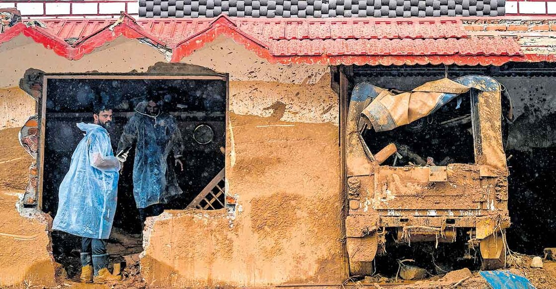 വയനാട്ടിലെ ഉരുൾപൊട്ടലിൽ തകർന്ന വീട്ടിൽ പരിശോധന നടത്തുന്ന രക്ഷാപ്രവർത്തകർ.