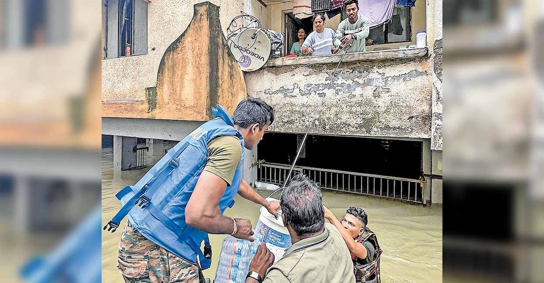 ഗുജറാത്തിലെ ഗാന്ധിനഗറിൽ പ്രളയത്തിൽ ഒറ്റപ്പെട്ടുപോയ വീടുകളിലേക്ക് ഭക്ഷണം എത്തിക്കുന്ന സൈനികർ. ചിത്രം:  പിടിഐ