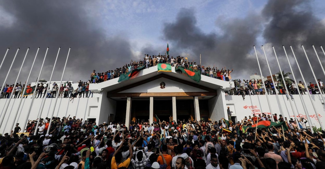 BANGLADESH-UNREST-STUDENTS ബംഗ്ലദേശിലെ ധാക്കയിൽ പ്രക്ഷോഭകാരികൾ പ്രധാനമന്ത്രി ഷെയ്ഖ് ഹസീനയുടെ ഔദ്യോഗിക വസതിയായ ഗണഭബനിലേക്ക് ഇരച്ചുകയറി ദേശീയ പതാക സ്ഥാപിച്ചപ്പോൾ.(Photo by K M ASAD / AFP)