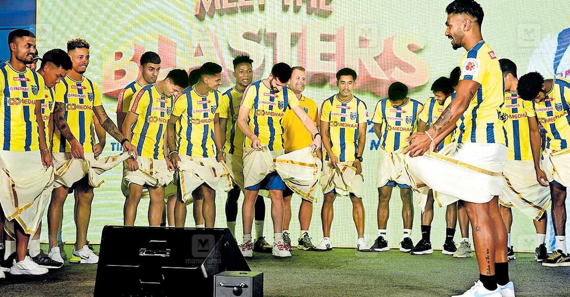 blasters-team-malayali-look കൊച്ചിയിൽ, പുതിയ സീസണിലെ കേരള ബ്ലാസ്റ്റേഴ്സ് ഫുട്ബോൾ ടീമിനെ ആരാധകർക്കു മുന്നിൽ അവതരിപ്പിച്ച ചടങ്ങിൽ, മുണ്ടു മടക്കിക്കുത്താൻ സഹതാരങ്ങളെ പഠിപ്പിക്കുന്ന മലയാളി താരം കെ.പി.രാഹുൽ. (ചിത്രം: അരുൺ ശ്രീധർ /മനോരമ)