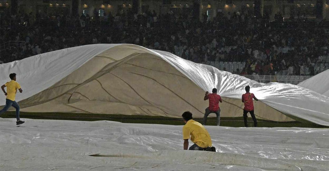 ഈഡൻ ഗാർഡൻസിലെ ഗ്രൗണ്ട് മഴമൂലം മൂടിയിട്ടപ്പോൾ.  (Photo by DIBYANGSHU SARKAR / AFP)