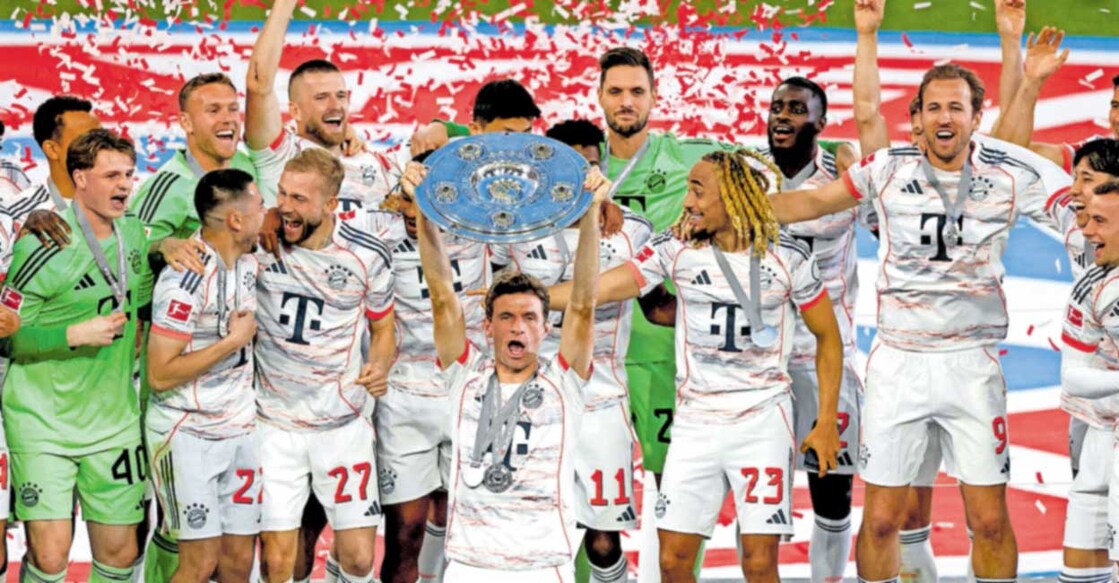 തോമസ് മുള്ളർ ബുന്ദസ്‌‌ലിഗ കിരീടവുമായി. ബയൺ മ്യൂണിക്ക് സഹതാരങ്ങൾ പിന്നിൽ.