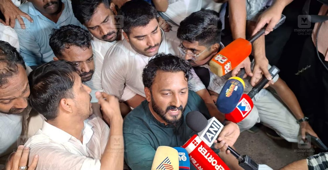 cpm-rahul-clash സി പി എം പ്രവർത്തകർ സംഘടിച്ചിട്ടുണ്ടെന്നും പിരിഞ്ഞ് പോകണമെന്നും പോലീസ് ആവശ്യപ്പെട്ടതിൽ രാഹുൽ മാങ്കൂട്ടത്തിലും പ്രവർത്തകരും റോഡിൽ കുത്തിയിരുന്ന് പ്രതിഷേധിക്കുന്നു. (ചിത്രം: മനോരമ)