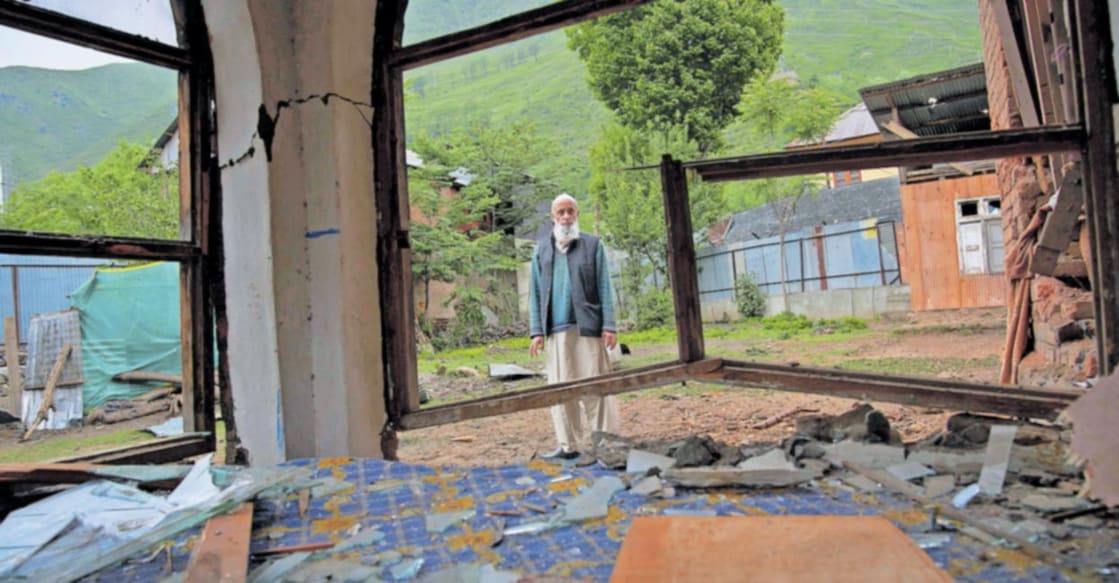 destroyed-house-pakistan-attack ഉറിയിൽ പാക്കിസ്ഥാൻ ആക്രമണത്തിൽ തകർന്ന വീടിനു സമീപം നിൽക്കുന്നയാൾ.
