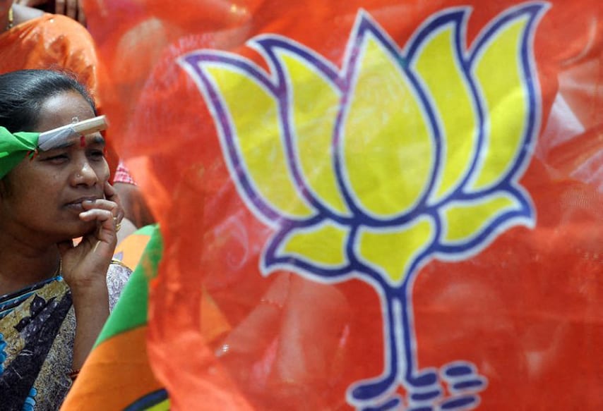 A woman activist of India's main opposition party, Bharatiya Janata Party(BJP) waves a party flag during a protest against recent rises in fuel prices in Bangalore on June 30, 2010 . India's government decided to hike fuel prices June 25, a politically contentious move analysts say could save the state 5.2 billion USD but exacerbate high inflation by as much as a percentage point. AFP PHOTO/Dibyangshu SARKAR (Photo by DIBYANGSHU SARKAR / AFP)