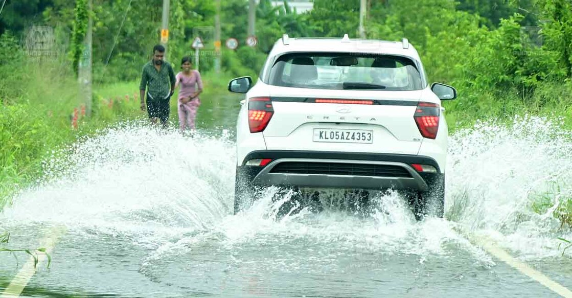 കോട്ടയം ജില്ലയിലെ പുതുപ്പള്ളി – പാലൂർപ്പടി റോഡിൽ ചെമ്മരപ്പള്ളിയിൽ റോഡിലെ വെള്ളക്കെട്ടിലൂടെയുള്ള യാത്ര. ചിത്രം : റിജോ ജോസഫ് ∙ മനോരമ