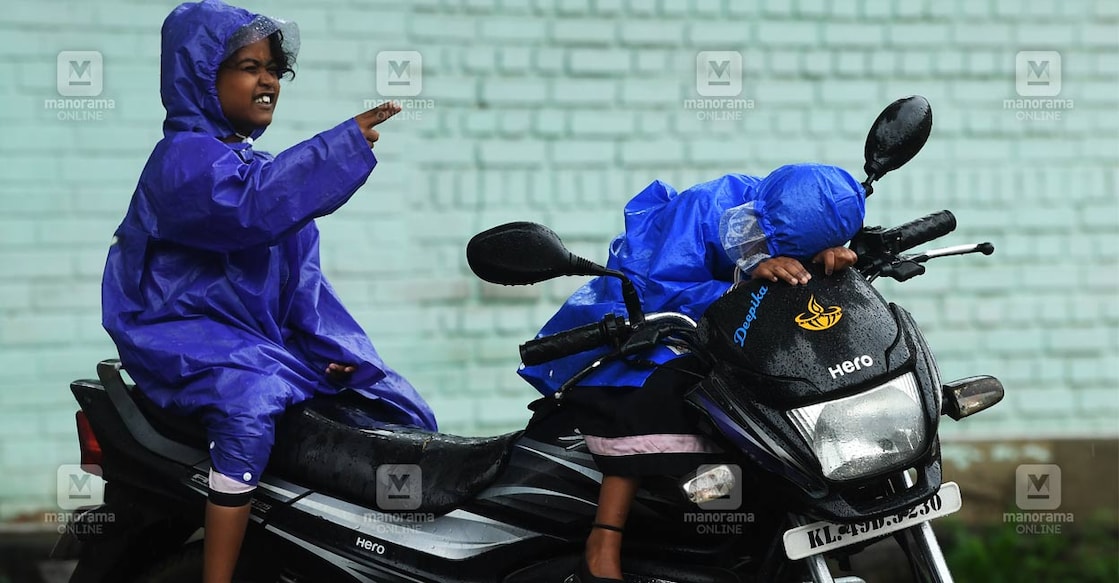 കഴിഞ്ഞ ഒരാഴ്ചയായി ജില്ലയിൽ മഴ ശക്തി പ്രാപിക്കുകയാണ്, ഒറ്റപ്പെട്ട ഇടങ്ങളിൽ മഴമൂലം ഉണ്ടാകുന്ന  അപകടങ്ങൾ ഒഴിച്ച് ജില്ലയിൽ ഇതുവരെ സ്ഥിതി ശാന്തമാണ്. ഇടവിട്ട് പെയ്യുന്ന മഴയെ ചെറുക്കാൻ റെയിൻ കോട്ടും ധരിച്ച്  കുഞ്ഞനുജത്തിക്കൊപ്പം മഴ ആസ്വദിക്കുന്ന കുട്ടി. പാലക്കാട് കാഴ്ചപ്പറമ്പിൽ സമീപത്ത് നിന്നുള്ള കാഴ്ച. ജില്ലയിൽ ഇന്ന് യെല്ലോ അലർട്ട് ആണ്. ചിത്രം : ഗിബി സാം ∙ മനോരമ   