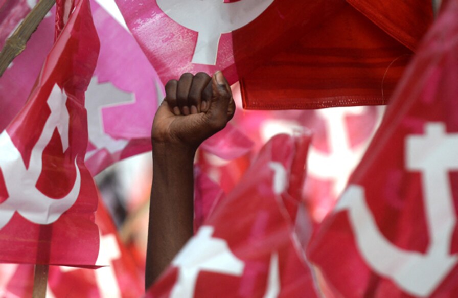 A demonstrator holds his fist in the air as members of Communist Party of India (CPI) along with Trade Unions demonstrate during a national wide protest demanding a standardization of minimum monthly wages of 18000 INR(USD $283) to working labors in Chennai on January 25, 2018. (Photo by ARUN SANKAR / AFP)