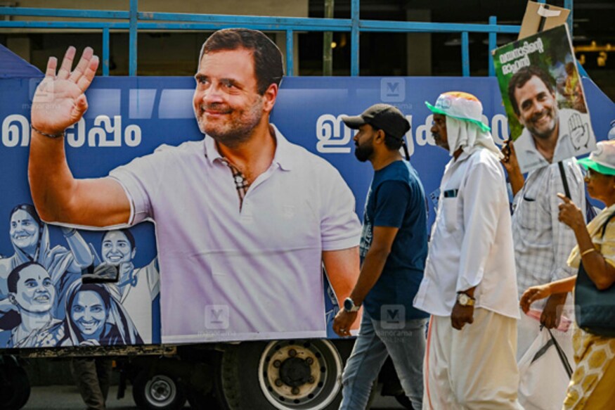 Supporters of India's Congress party walk past a cutout of their leader Rahul Gandhi along a street during a roadshow in Wayanad on April 3, 2024. (Photo by R.Satish BABU / AFP)