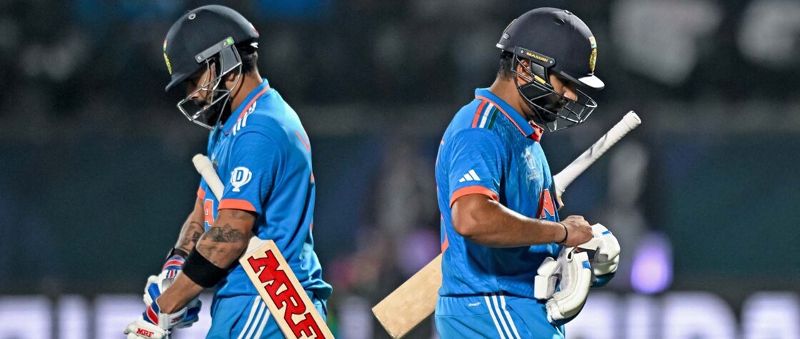 India's Virat Kohli arrives to bat as team's captain Rohit Sharma (R) walks back to the pavilion after his dismissal during the 2023 ICC Men's Cricket World Cup one-day international (ODI) match between India and New Zealand at the Himachal Pradesh Cricket Association Stadium in Dharamsala on October 22, 2023. (Photo by Money SHARMA / AFP) / -- IMAGE RESTRICTED TO EDITORIAL USE - STRICTLY NO COMMERCIAL USE -- - -- IMAGE RESTRICTED TO EDITORIAL USE - STRICTLY NO COMMERCIAL USE --