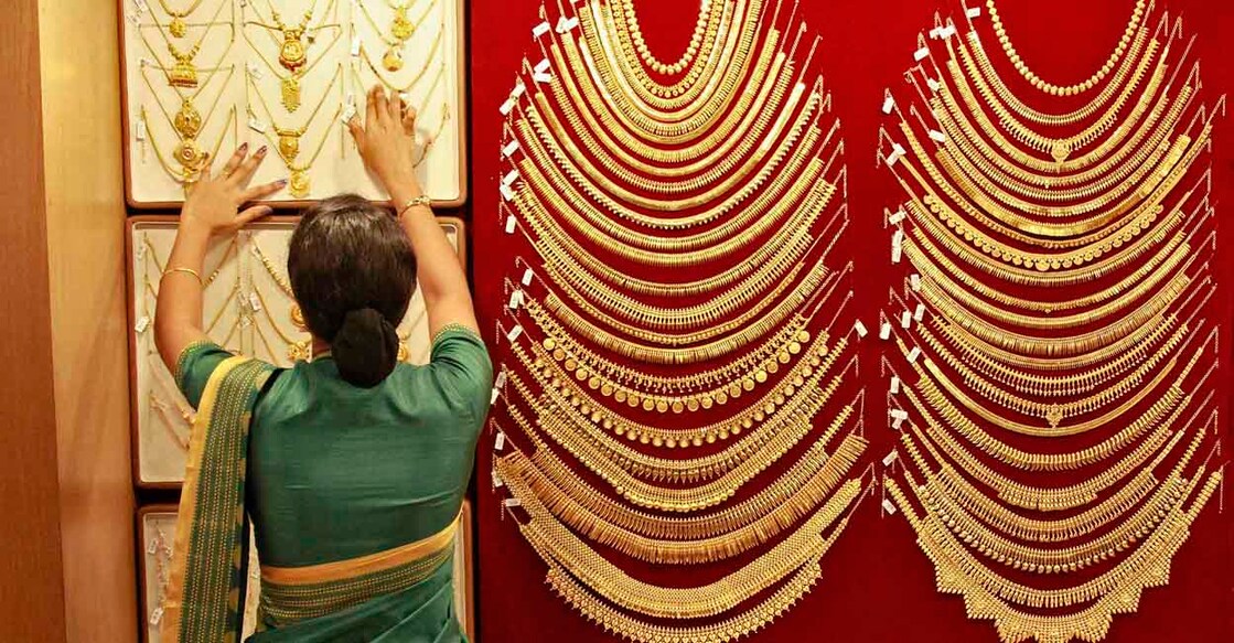 A saleswoman arranges a gold necklace inside a jewellery showroom in the southern Indian city of Kochi April 16, 2013. Gold futures in India, which hit the lowest level in more than 18 months on Tuesday, may stage a recovery as key technical indicators point to the yellow metal entering oversold territory, according to analysts. REUTERS/Sivaram V (INDIA - Tags: BUSINESS)