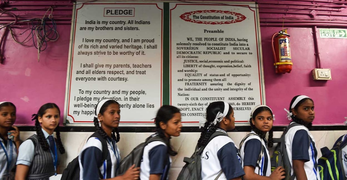 Students walk past a board showing the preamble of India's constitution at the Air India Modern School in Mumbai on January 27, 2020. (Photo by Indranil MUKHERJEE / AFP)