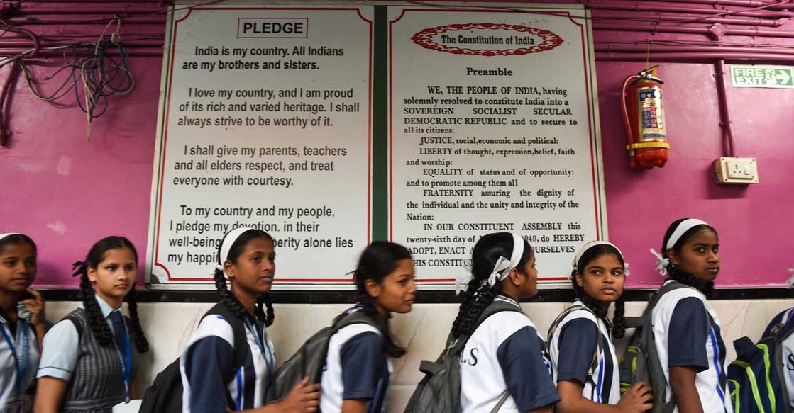 INDIA-POLITICS-EDUCATIOIN-CONSTITUTION Students walk past a board showing the preamble of India's constitution at the Air India Modern School in Mumbai on January 27, 2020. (Photo by Indranil MUKHERJEE / AFP)