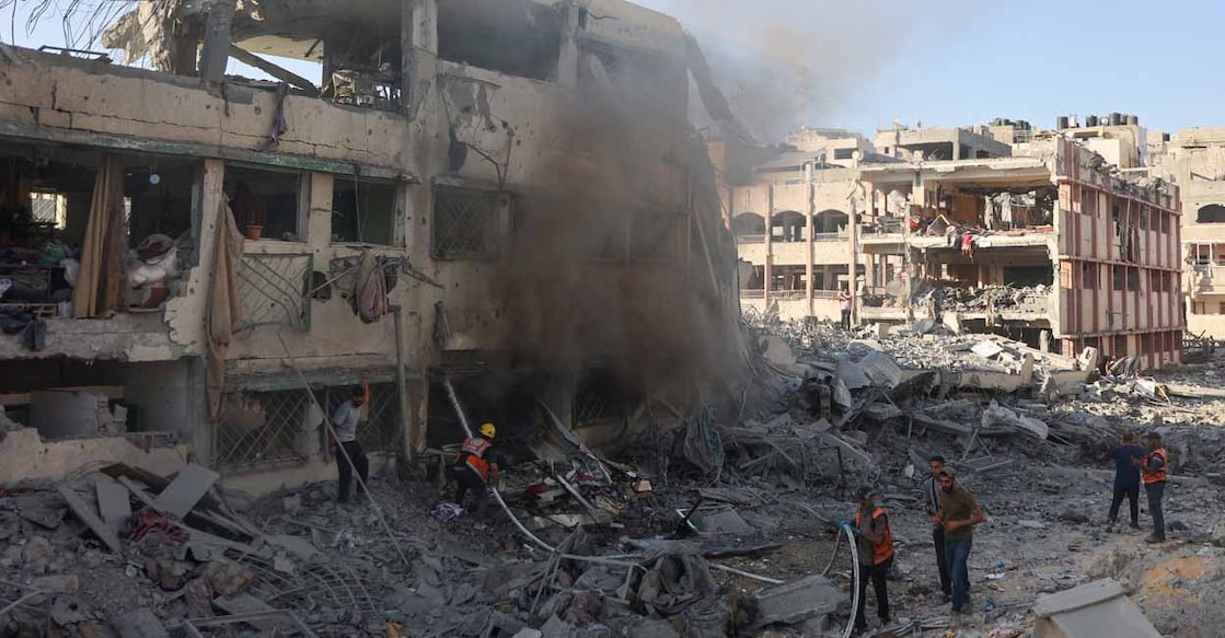 PALESTINIAN-ISRAEL-CONFLICT Palestinian rescuers extinguish a fire in a destroyed building following Israeli bombardment which hit a school complex, including the Hamama and al-Huda schools, in the Sheikh Radwan neighbourhood in the north of Gaza City on August 3, 2024, amid the ongoing conflict between Israel and the militant Hamas group. (Photo by Omar AL-QATTAA / AFP)