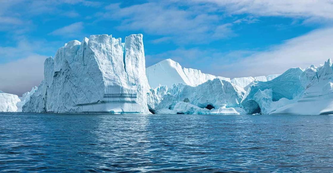 1457342613 panoramic view of giant icerbergs flotaing on the arctic sea at Ilulissat icefjord in a sunny day. Melting ice. Climate change concept. Greenlad