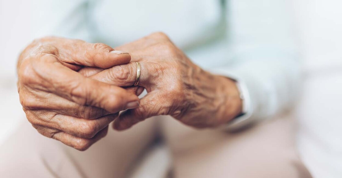 Heartbroken elderly woman holding he husbands wedding ring