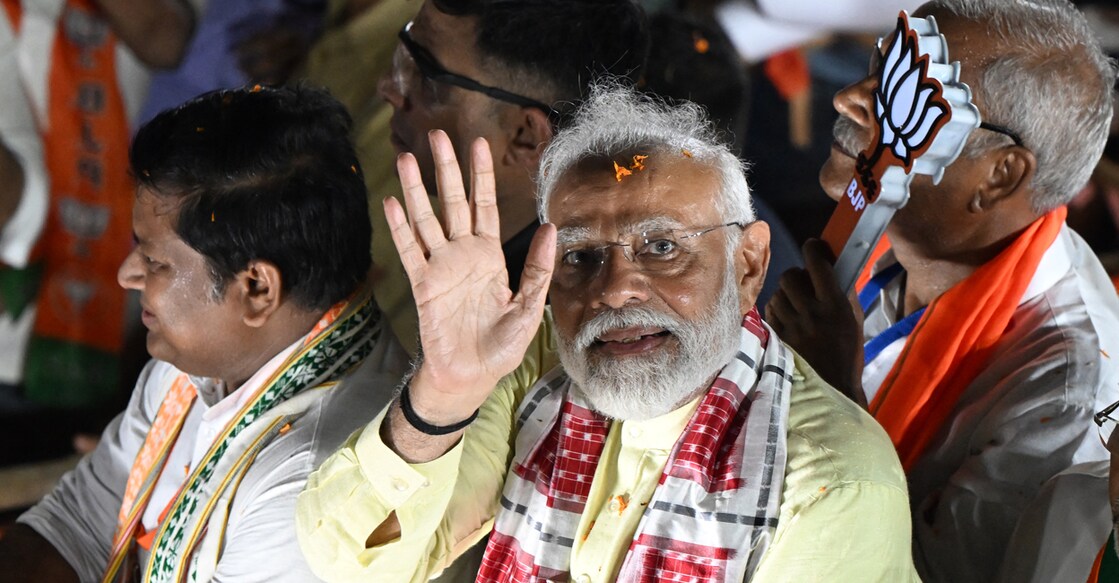 India's Prime Minister and leader of ruling Bharatiya Janata Party (BJP) Narendra Modi (C) greets his supporters during an election campaign rally, in Kolkata on May 28, 2024, ahead of the seventh and final phase of voting in country's general election. (Photo by DIBYANGSHU SARKAR / AFP)