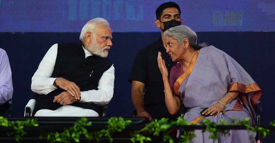 Indian Prime Minister Narendra Modi (C) and Finance Minister Nirmala Sitaraman (R) speak during the launch of the India International Bullion Exchange and the NSE IFSC-SGX Connect at the GIFT City near Gandhinagar on July 29, 2022. (Photo by SAM PANTHAKY / AFP)