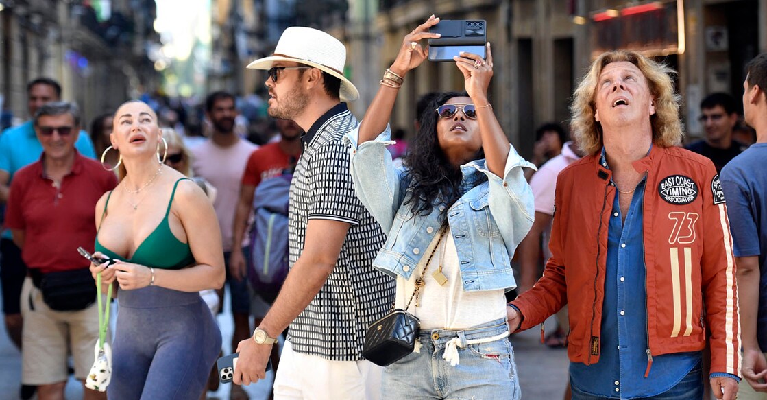 Tourists take pictures in the old town of the Spanish Basque city of San Sebastian on August 23, 2024. - Close to 41 million international tourists are expected to visit Spain this summer in what would set a new record, as local protests against overtourism multiply. If the predictions are correct, the figure would be 13 percent higher than the numbers visiting in summer 2023, which was also a record. (Photo by ANDER GILLENEA / AFP)