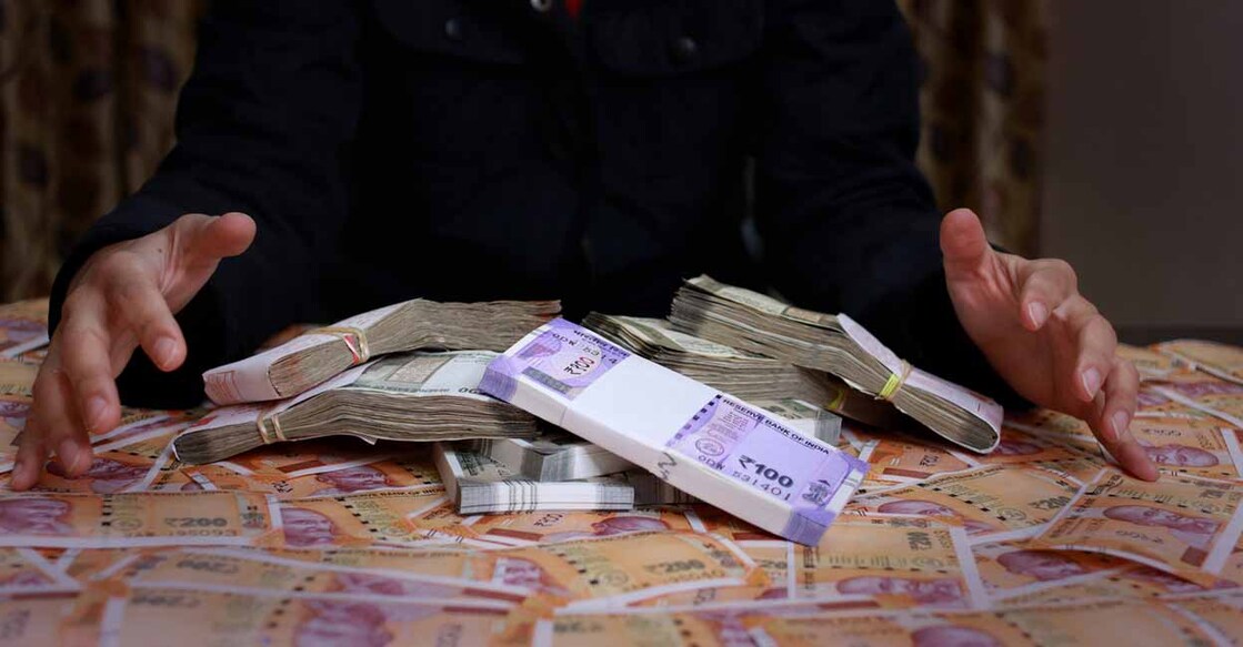 Businesswoman collecting cash on the table.